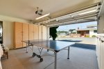 The garage has a ping pong table and flatscreen TV